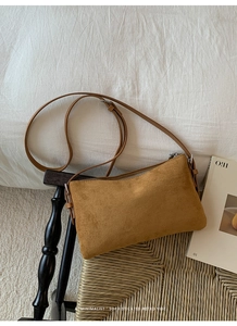 Détail du sac à bandoulière en daim marron avec texture mate et fermeture éclair