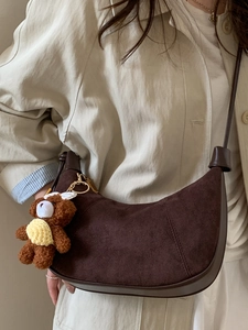 Brown suede half-moon dumpling bag for women with a cute plush bear charm on strap