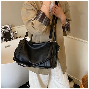 Détail d'un sac cylindrique noir minimaliste présenté dans un cadre de vie très élégant