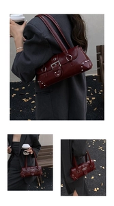 Detail view of burgundy leather shoulder bag with silver rivet studs and metal buckles