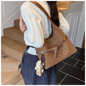Detalle del bolso de hombro vintage con estampado de leopardo y un llavero de oso peludo