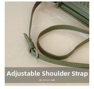 Detail of adjustable green shoulder strap with white stitching and silver metal buckle