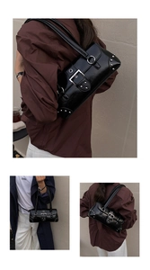 Detail view of black underarm bag with silver rivets and punk style metal buckles