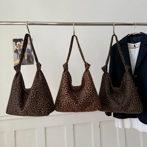 Drei stylische Hobo-Taschen mit Leopardenmuster und Knotengriffen an einer Metallstange