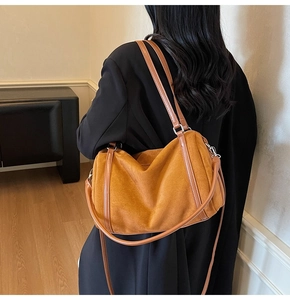 Detailed back view of a large brown suede Boston bag styled over a model's shoulder