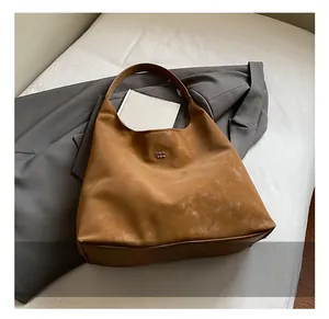 Vue détaillée du sac hobo marron avec texture mate et petit logo métallique sur le devant