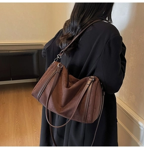 Detail view of large brown suede hobo bag showing texture and shoulder carry effect