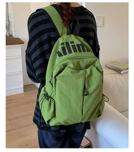 Detail view of avocado green travel backpack with kilin logo and side drawstring pocket
