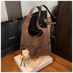 Detalle de bolso tote de ante con estampado de leopardo y colgante de osito café