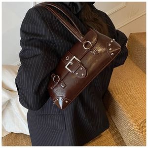 Close-up of vintage dark brown glossy shoulder bag with silver metallic hardware and rivets
