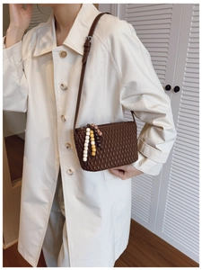 Brown pleated PU leather shoulder bag with colorful bead charms worn by model