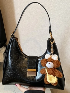 French vintage black hobo bag in oil wax leather with a cute plush bear charm