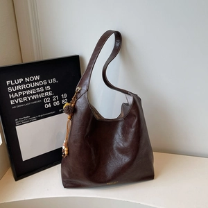 Detail view of dark brown hobo bag with vintage texture and wooden bead tassel