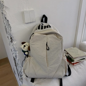 Detail of cream large-capacity backpack with nylon texture and cute puppy pendant