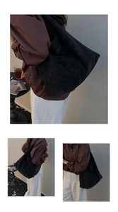 Gros plan détaillé d'un sac cabas en daim noir mat avec un logo GEM doré élégant