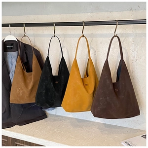 Sacs hobo minimalistes en daim en quatre couleurs présentés sur un portant en métal chic