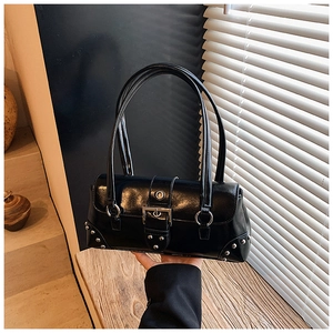 Detail of black glossy underarm bag with silver rivets and metal buckle hardware