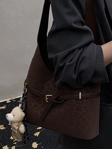Bolso saco de ante con estampado de leopardo, amuleto de osito y detalle de hebilla metálica
