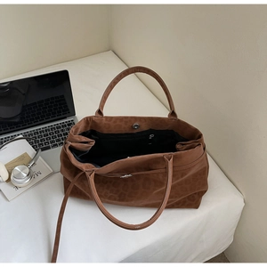 Spacious faux suede leopard print tote bag styled with office accessories on white background