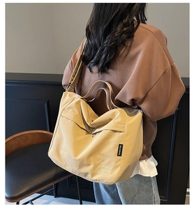 Detail view of khaki waterproof tote bag featuring puppy embroidery and wide shoulder strap