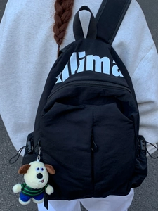 Lightweight black large capacity travel backpack with white logo and dog plush pendant