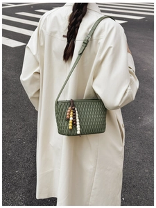 Detailed view of dark green quilted shoulder bag with vintage colorful beaded strap decor