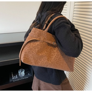 Detail of large brown leopard print suede tote bag showing capacity and long handles