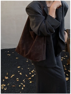 Détail du grand sac cabas en daim marron foncé avec texture souple et large bandoulière