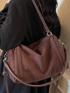 Large dark brown suede tote bag with leather trim and adjustable strap shown on model