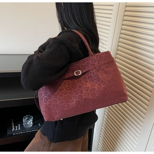 Detail of burgundy leopard print suede tote bag with stylish buckle strap and large capacity