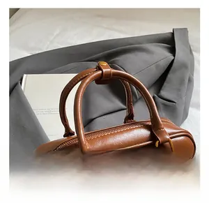 Detail shot of a brown vintage leather Boston handbag with embossed MIRA text and metal zipper