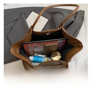 Interior detail of large brown leather tote bag with storage space and magnetic buckle