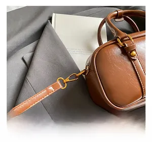 Detail of brown vintage crossbody bag with premium gold metal hook and leather texture