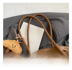 Detail showing high-quality lychee pattern leather and exquisite stitching on brown tote bag