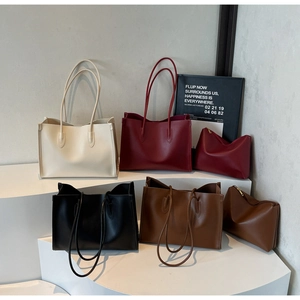Macro shot of large faux leather tote bags in four colors with matching zipper pouches