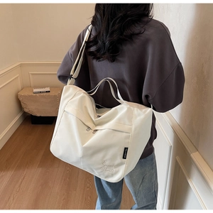 Close-up of beige waterproof nylon tote bag featuring cute dog embroidery and logo label