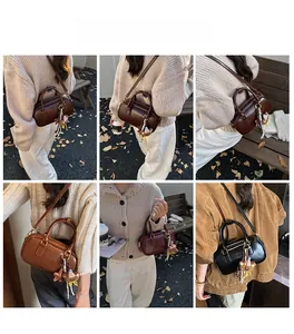 Détail du sac bandoulière vintage de style docteur avec texture cuir et breloque ours