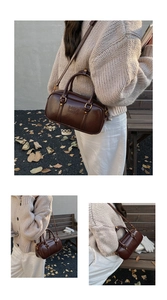 Detail of vintage coffee brown leather Boston bag with Mira Mira embossed logo and gold hardware