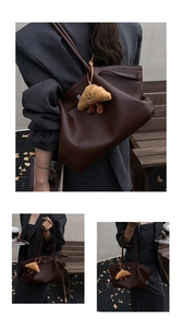Detail of dark brown tote bag with premium pebbled texture and plush croissant pendant