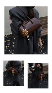 Detail of dark brown polished leather bag with long strap and small teddy bear charm