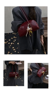 Detail of dark red bowling bag in glossy leather with a cute brown knitted bear charm