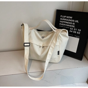 Close-up of cream canvas tote bag showing zipper pocket and cute dog embroidery detail