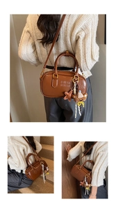 Détail d'un sac Boston en cuir marron avec pendentif ours et breloque étoile de mode