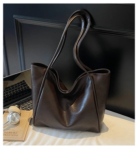 Detail of dark brown vintage tote bag with slim straps and spacious leather interior