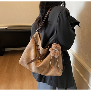 Retro khaki suede tote bag with brown leather strap and decorative bear charm detail