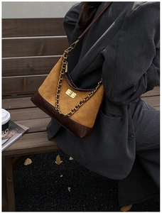 Detail of vintage suede crossbody bag with rhombus stitching and golden mechanical lock