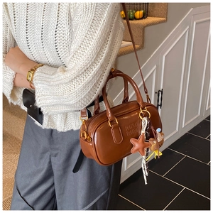 Sac boston en cuir marron avec lettres embossées, détails dorés et charms mignons