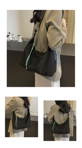 Detail of black canvas hobo bag with a bright green decorative woven rope zipper puller