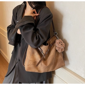 Detail of vintage brown tote bag texture with silver eyelet and cute bear charm