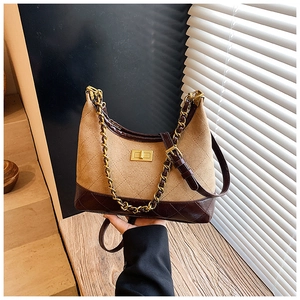 Detail of tan suede and dark leather crossbody bag with chain and rhombic stitching